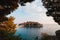 View through green tree branches to Sveti Stefan island