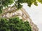 View through green trees of dream parisian apartment building real estate in