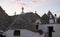 View of group of traditional trulli houses in the Aia Piccola residential area of Alberobello, Puglia Italy