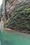 View of the GuadalevÃ­n River with its turquoise waters and the rocky hillside with green plants or moss