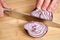 View on hands of a man chopping peeled fresh red onion for lunch an a bamboo cutting board.