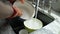 View of Hands in orange gloves wash dishes in the kitchen. Slow motion