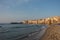 View of harbour with old houses and public beach at Cefalu at sunset, Sicily. Italy