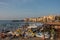 View of harbour with old houses and public beach at Cefalu at sunset, Sicily. Italy