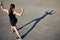 View from a height of an athlete who shows her biceps and looks at her shadow.