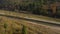 View from the height on the autumn landscape - river, railway, forest on a mountainside, cars on the road