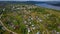 View from the height . Clip . A small summer village with a river, small residential houses and roads, a green forest