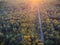 View from a height down on the autumn forest in a golden hour. Sunset, golden hour. There is a road in the woods