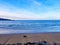 View of Hendaya beach at sunset. With dog walking on the sand and surfers in the sea waiting for the wave