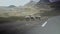 View of herd of sheeps walking by the side of the road leading towards the grazing fields by the Lake Ayous in the