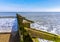 A view of the high and low sides of sea defense Groynes on Skegness beach with a wind farm  just visible on the horizon