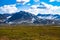 View of high mountains with snow, grass in foreground