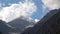 View of high snowy mountains with clouds in the sky.