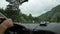 View of the highlands through the windshield. dashboard and steering wheel with driver`s hands, morning fog on the