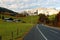 View of a highway passing by a farm land with a church on top of the hill