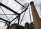 View of the historic canal chain bridge in Huddersfield West Yorkshire with large old mill building with a tall stone chimney