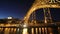 View of the historic city of Porto, Portugal with the Dom Luiz I bridge at night time.