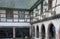 View of a historic half-timbered Alsation country house and courtyard with old horse-drawn carriages in open garages