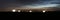 View of the historic white windmills of La Mancha above the town of Campo de Criptana at dusk