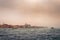 View of historical buildings surrounded by water in the morning mist in the city of Venice