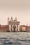 View of historical buildings surrounded by water in the morning mist in the city of Venice