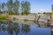 View of an historical weir system. In the background there is a row of poplars