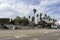 View of homeless tents lining to freeway in Los Angeles. Apartment buildings in the background