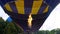 View of hot air balloon burner directing flame into envelope, floating in sky