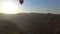 View of hot air balloon flying over mountain valley and Armenian village, sunset