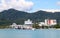 View of hotel and building and ship standing near beach with background of green hills