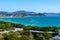 View from the hotel to clear turquoise sea, mountains, beach, jet skis, motor boats and parachutes on the coast of Dadonghai Bay