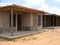 View of a house construction with wooden slats and cement.