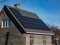 View of a house with mounted and installed photovoltaic solar panels on the roof. Rooftop with solar cells for heating and