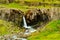 View of icelandic waterfall with the moss covered volcanic rocks