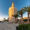 A view on the iconic golden tower on the quayside of the river Guadalquivir in Seville on a sunny afternoon