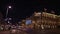 View of the illuminated facade of the Vienna State Opera building in Austria by night with tram in front.