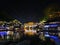 View of illuminated at night riverside houses in ancient town of Fenghuang known as Phoenix