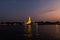 View of Illuminated Wat Arun Temple from the Chao Phraya river in sunset. Buddhist temple in Bangkok