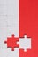 View of incomplete jigsaw near white puzzle piece isolated on red