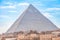 View of the incredibly majestic pyramid of the cheops on a sunny day in the desert with ancient ruins