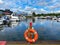 View on inland port with boats in summer with orange lifebelt, sealife building background