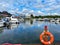 View on inland port with boats in summer with orange lifebelt, sealife building background