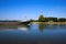 View on inland waterway vessel cargo ship on river Ijssel in rural dutch landscape against blue summer sky