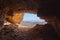 View from the inside of a cave to the rocky desert in the Sahara in Sudan lying under a glistening sun