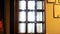 VIew inside of historical museum, glass window with wooden partitions and ancient documents hanging on the wall in