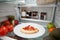 View Inside Refrigerator Of Leftover Takeaway Pizza Slice On Shelf