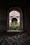 View inside ruined old dilapidated church, dry plants visible through arch, vault.