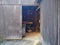 View inside the wooden barn through the open door. Old barn with a tractor inside. Sun rays falling into a country house.