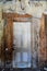 View of an interior doorway with rotting walls and decaying ceiling in Bannack Ghost Town in Montana