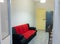 View of the interior of a small living room with kitchen of a two-room apartment. Gray laminate wood flooring, matching the walls